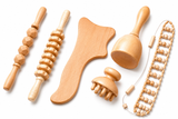 Six-piece wooden maderoterapia kit laid out flat: two roller sticks, contour paddle, cup, mushroom massager and beaded roller