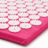 Close-up of the white massage spikes on the rose-pink acupressure mat