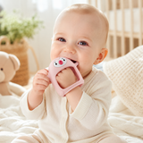Baby happily using the Never-Drop Silicone Teether in nursery