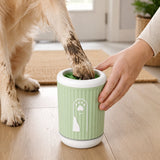 Dog paw being cleaned inside the green silicone paw cleaner cup at home