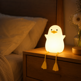 Duck night light glowing softly on a bedside nightstand in a cozy bedroom