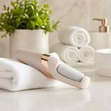 Electric callus remover resting on a folded towel in a bright spa bathroom