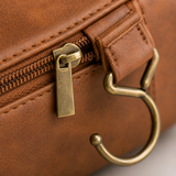 Close-up of the antique brass zipper, leather pull tab and metal hanging hook