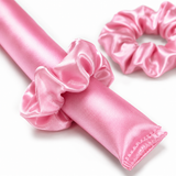 Close-up of the soft pink satin texture of the heatless curling rod and scrunchie