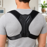 Person wearing the black posture corrector brace on their upper back