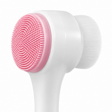 Close-up of the dual-sided design: pink silicone bristles and white fiber brush