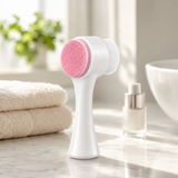 Facial cleansing brush on a bright marble bathroom vanity with a towel