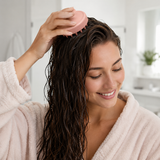 Woman using the pink silicone scalp massage brush on damp hair