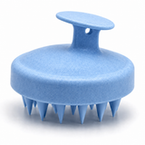 Blue silicone scalp massage brush on white background