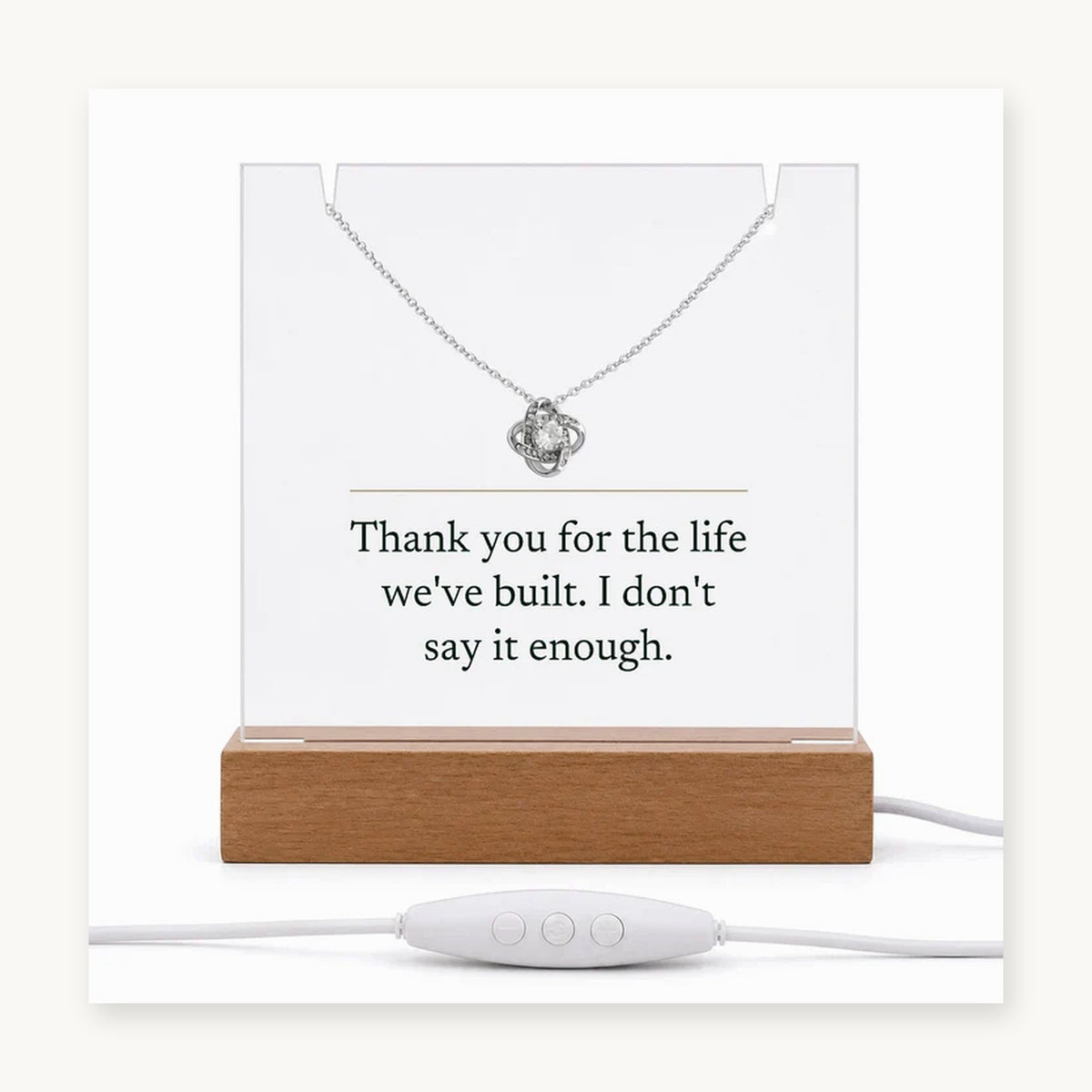 The Keepsake Set on its wooden LED base with the Love Knot necklace, the acrylic printed: Thank you for the life we've built. I don't say it enough