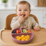 Baby in a high chair eating from the suction baby plate